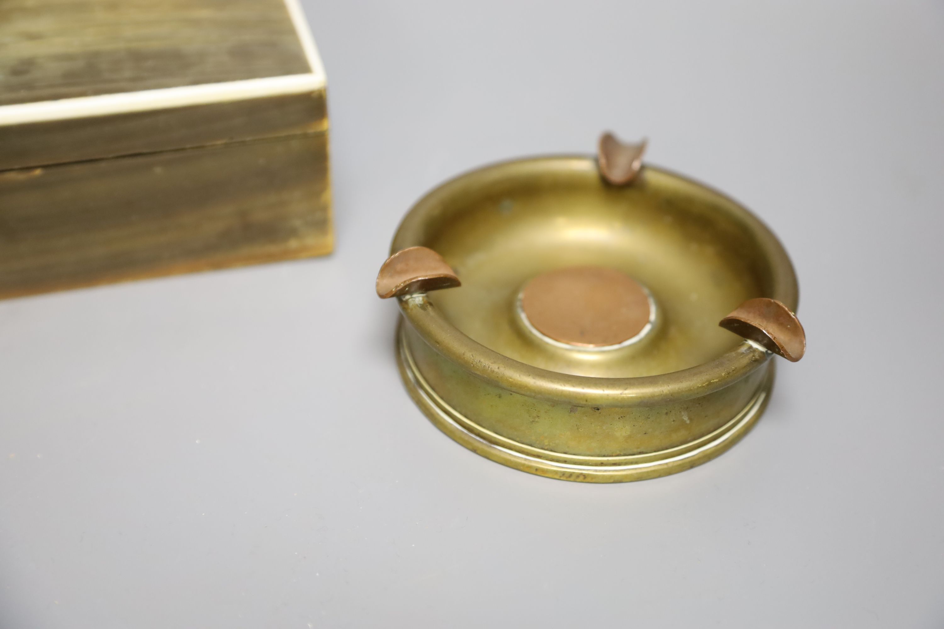 A horn veneered cigarette box, a horn handled magnifying glass and a Trench art ashtray